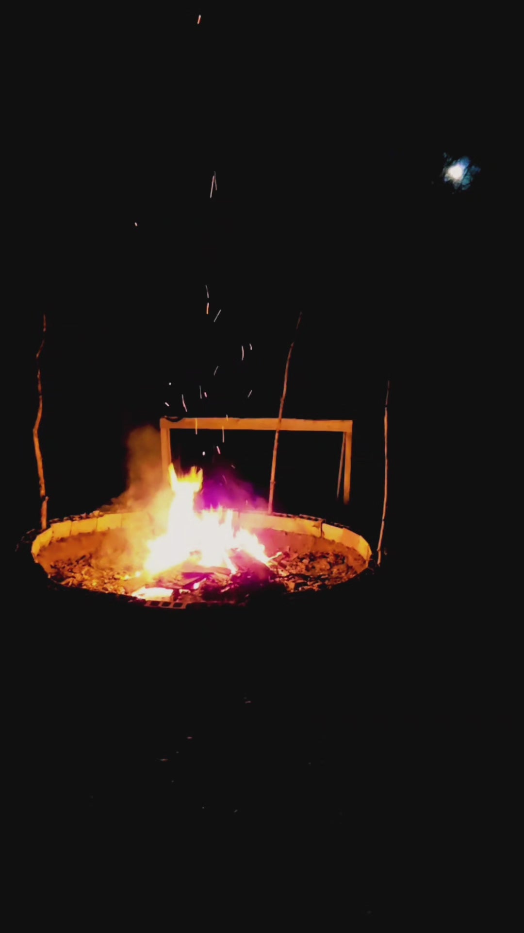 Load video: Video is of a large burning fire pit in the middle of the witch&#39;s home forest, late at night, with the full moon shining brightly in the background, during a lunar eclipse, and turning into a full blood moon seen through the trees.